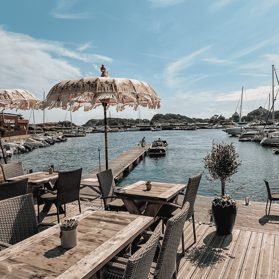 utendørsmøbler på brygge med utsikt mot sjø og båthavn