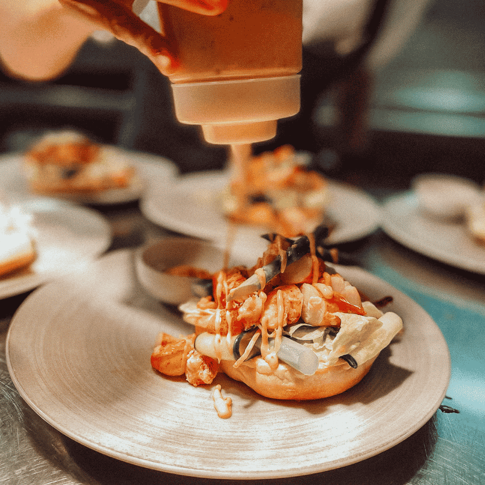 smørbrød på fat pyntes med saus fra en flaske
