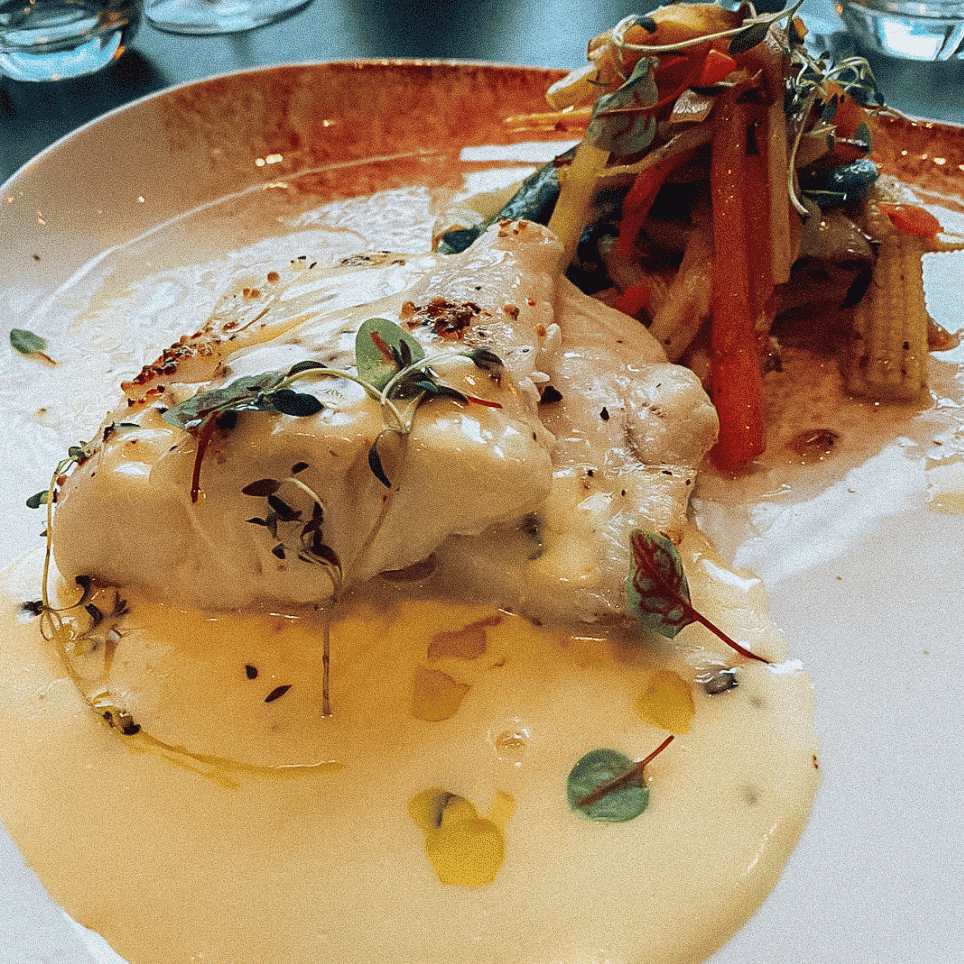 Hvit fIsk med saus og grønnsaker