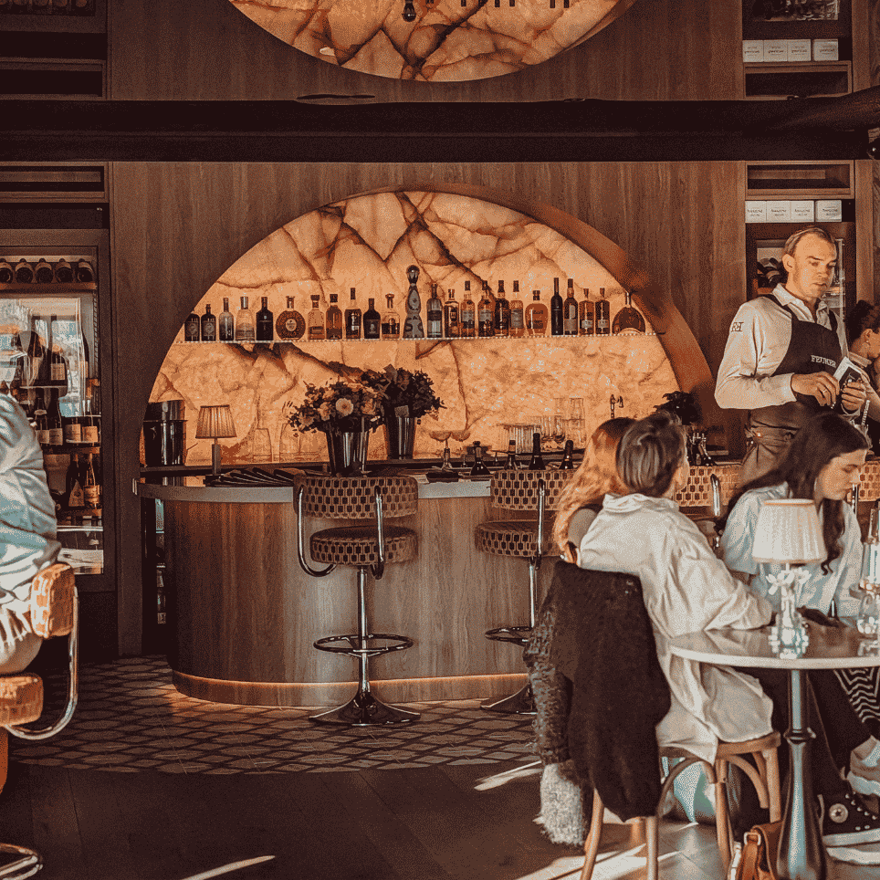 En opplyst bar med barstoler  og gjester