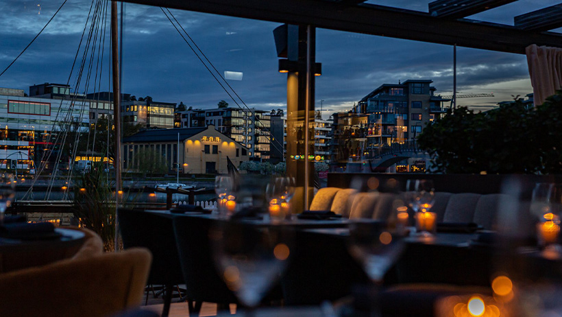 bord og sofaer på uteservering med sjøutsikt