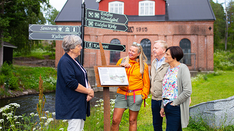 Personer med guide ved skilt