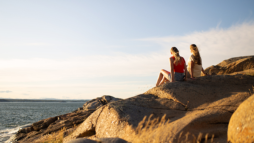 to personer sitter på svaberg ved fjorden i Sandefjord