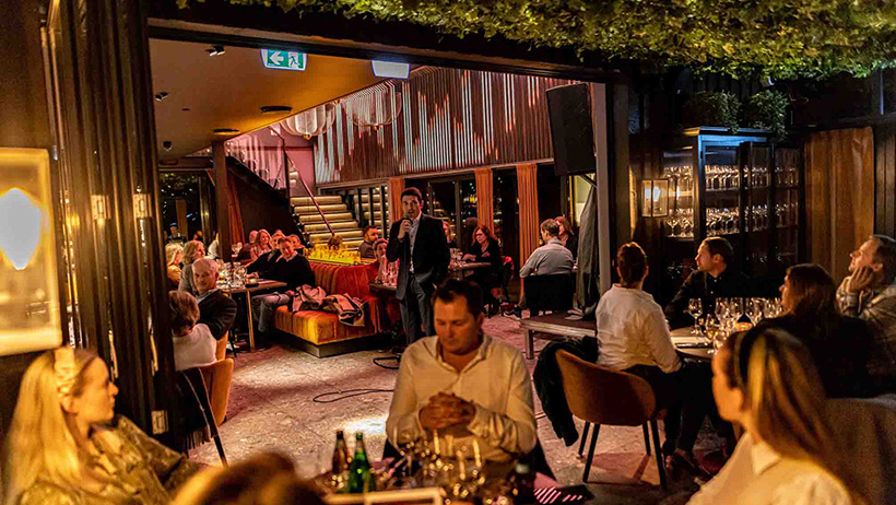 mange mennesker i restaurant som sitter ved bord