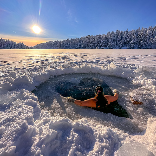 person bader i isen i et hull formet som hjerte