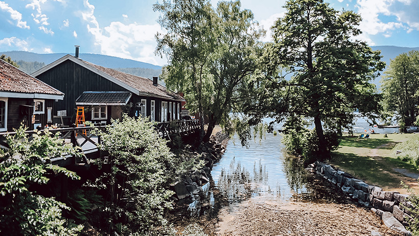 utsikt mot vann med trehus ved vannkanten