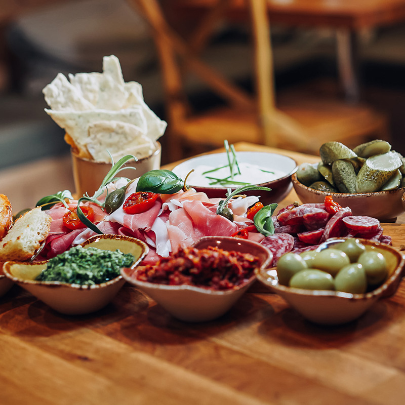 tapas småretter med spekemat, oliven og sauser på en fjøl