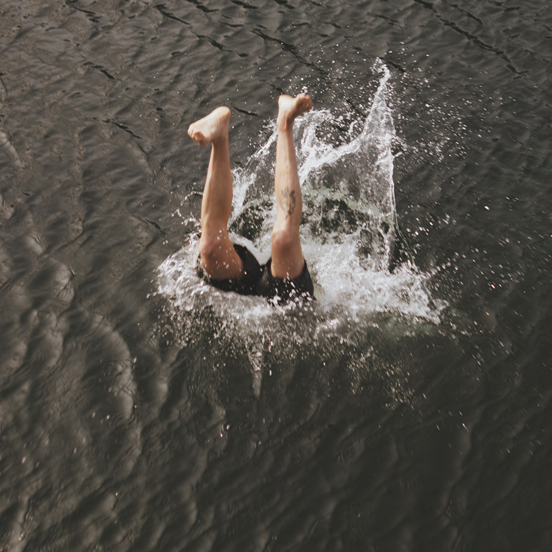 Bein stikker opp fra sjøen etter person har stupt.
