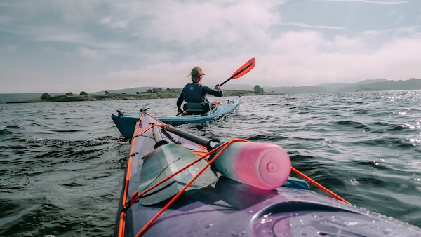 rosa flaske på en kajakk med en kajakk i front
