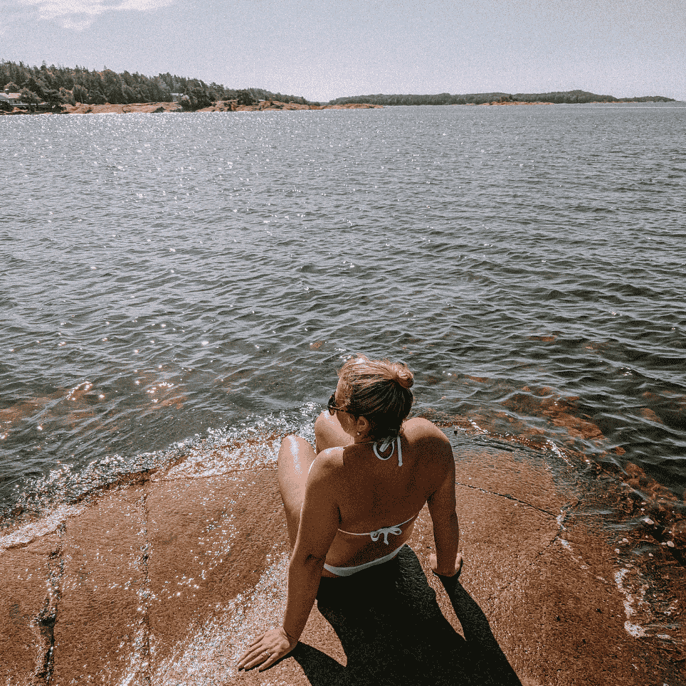 person på svaberg foran sjøen