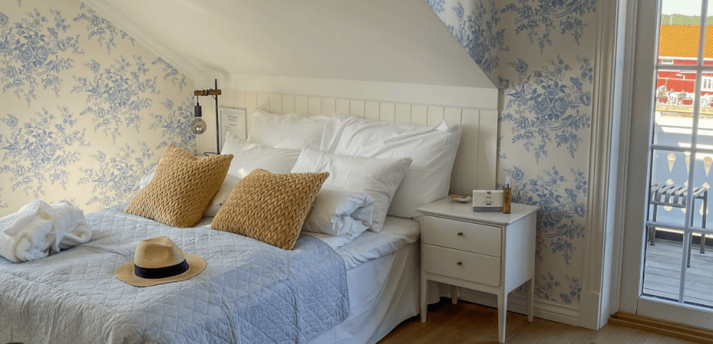 Hotellrom med seng og blå og hvite vegger