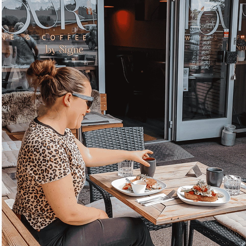 Person sitter og spiser utenfor en glassvegg 