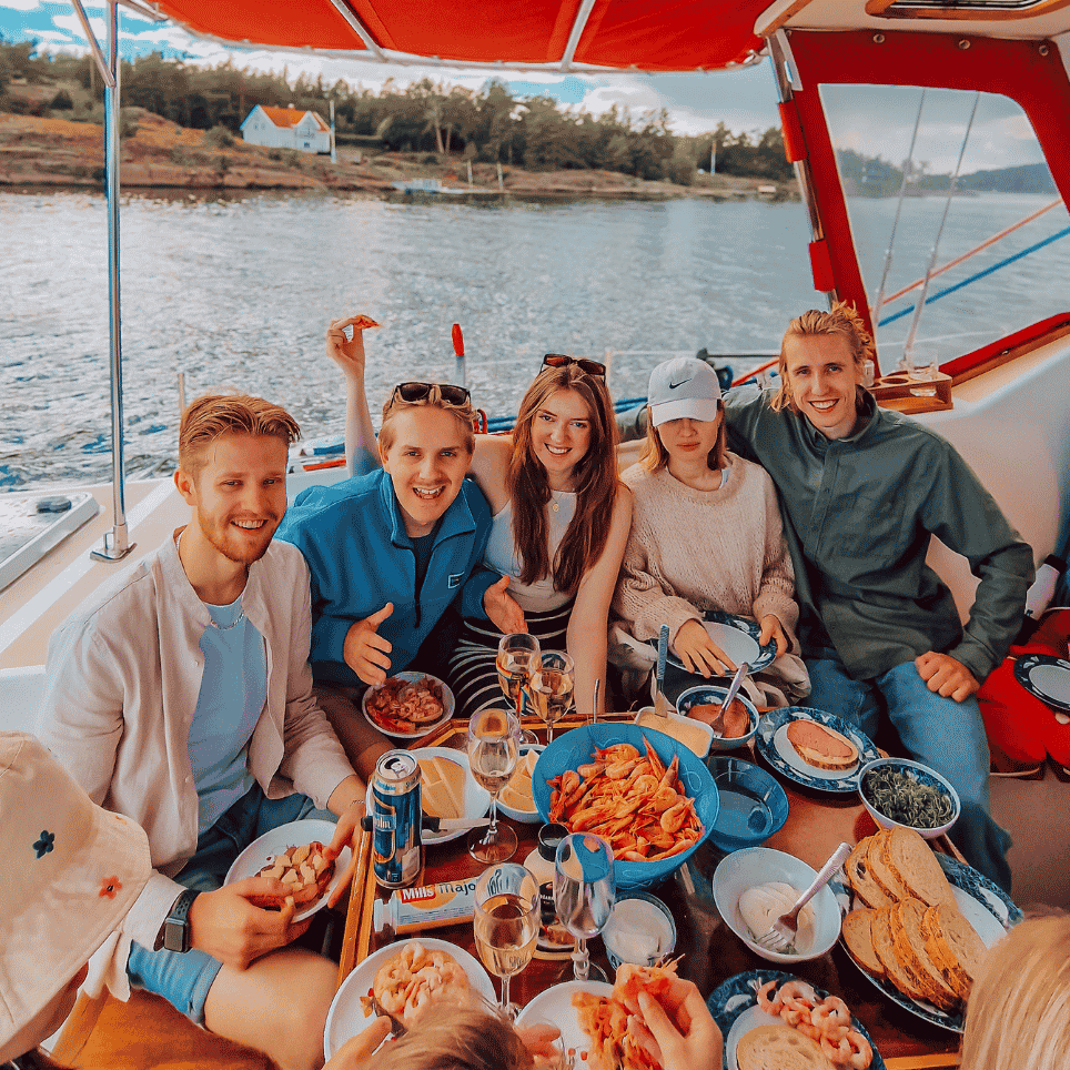 Vennegjeng rundt bord med reker og hvitvin