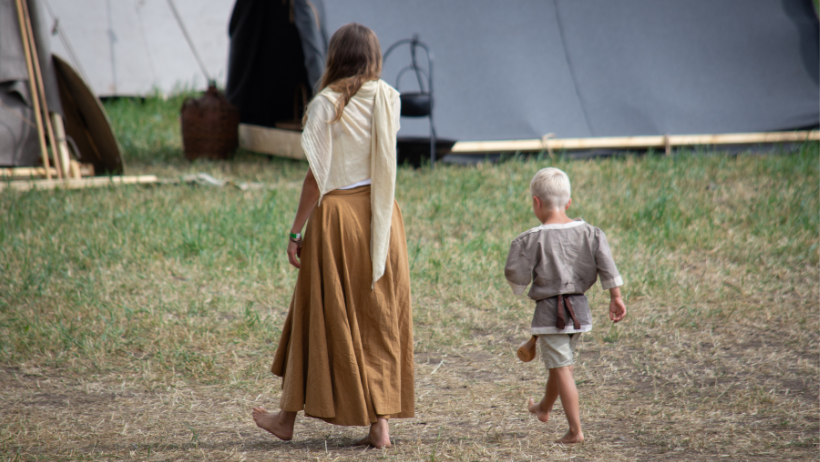 En mor og liten gutt går i vikingklær