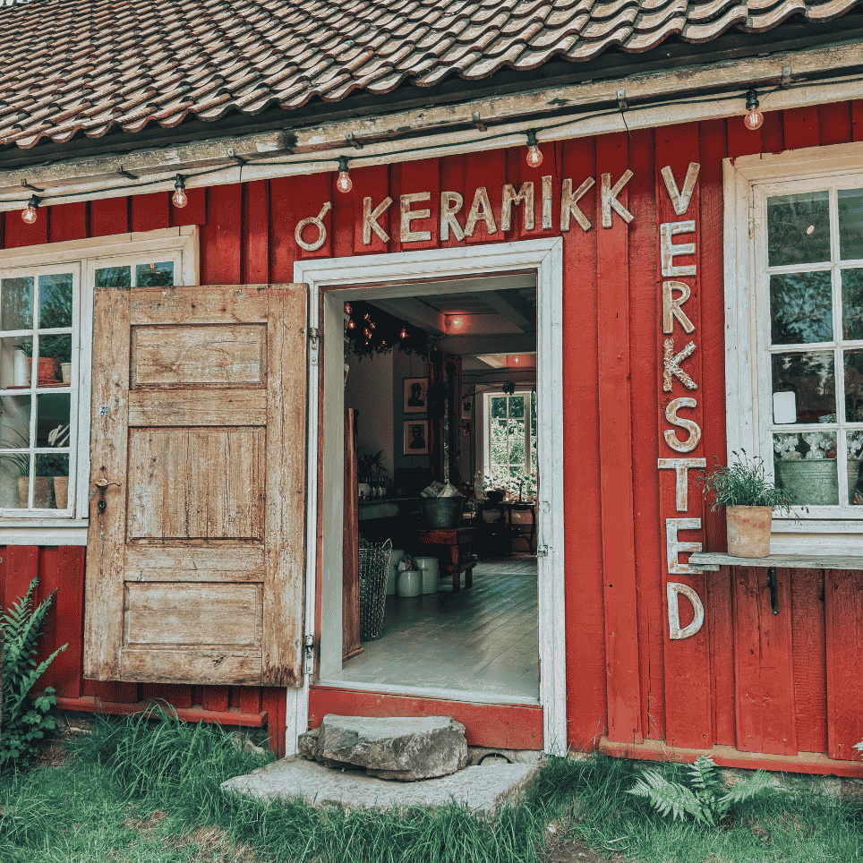 a red wooden house with ‘ceramics workshop’ written on the wall