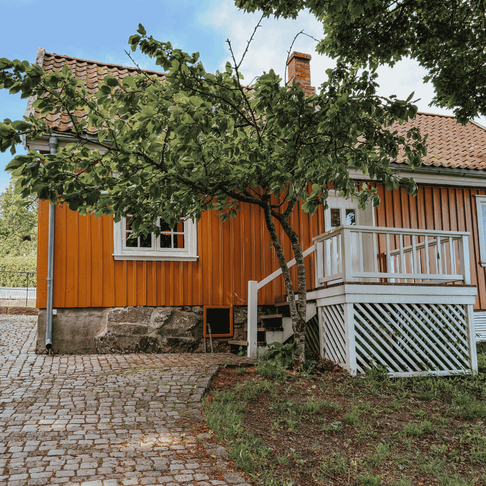 A yellow wooden building with an open door and a threshold ramp, with handrails on either side of the entrance.
