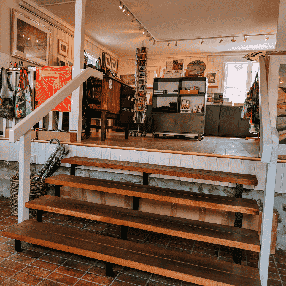 A museum shop with T-shirts, patterned bags and souvenirs displayed on shelves and racks.