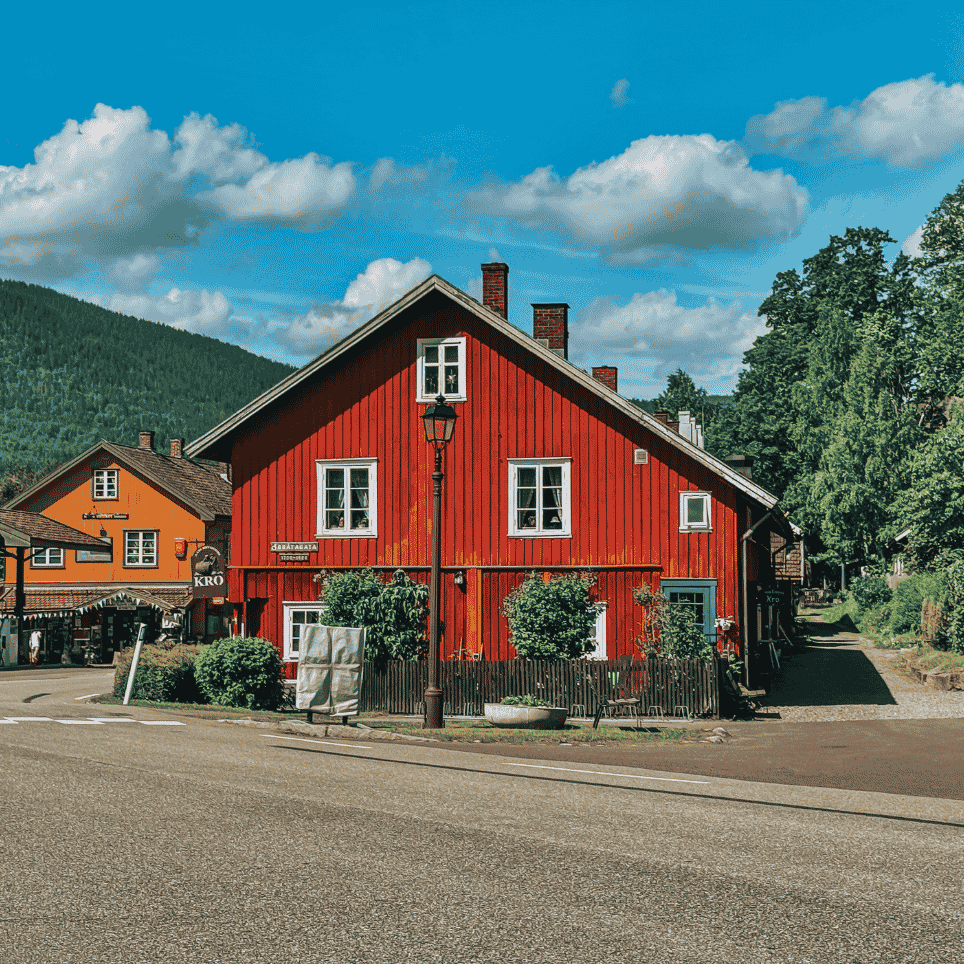 A red wooden house on a street corner, with a street lamp and a tarmac road in the foreground.